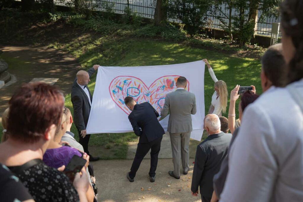 ausschneiden eines Herzes durch das gleichgeschlechtliche Paar vor den Augen der Hochzeitsgäste in Dresden