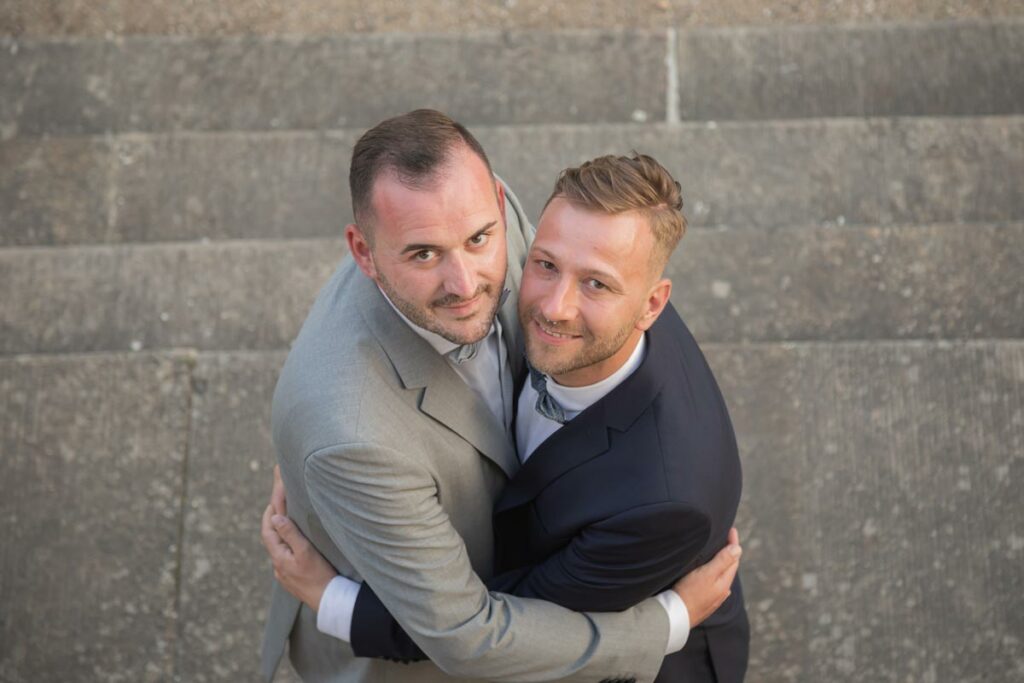 liebvolle umarmung mit dem zwei männern - dem brautpaar - gay wedding