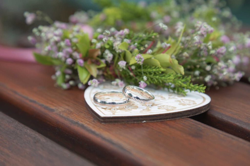 Eheringe des Brautpaares - Detailaufnahmen mit Blumen