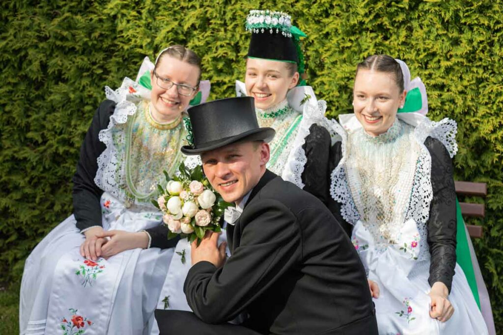 Jan Windisch, Hochzeitsfotograf für Bautzen hat eine sorbische Hochzeit fotografiert, zu sehen ist der Bräutigam, seine Frau und Hochzeitsgäste in sorbischen Sachen.