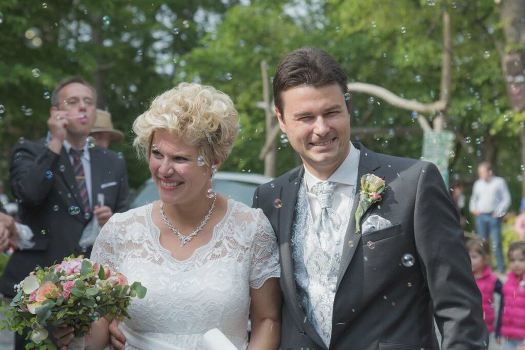 Das Brautpaar wird von seinen Hochzeitsgästen empfangen. Alle sind sehr glücklich und zufrieden. Dabei werden auch jede Menge Seifenblasen zur Begrüßung gemacht. So schöne Fotos erhalten Sie vom Hochzeitsfotograf aus Freiberg, professionell und einzigartig - so wie ihr!