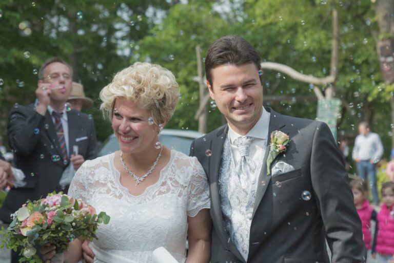 Hochzeitsfotogrrafie in Bautzen - professioneller Hochzeitsfotograf für die Region Bautzen und die Oberlausitz zu sehen ist ein Brautpaar, welches von den Hochzeitsgästen empfangen wird. beide strahlen...