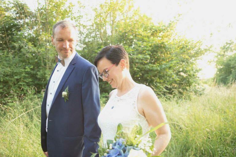 Hochzeitsfotos in Bautzen - ein Brautpaar geht auf einer Wiese entlang