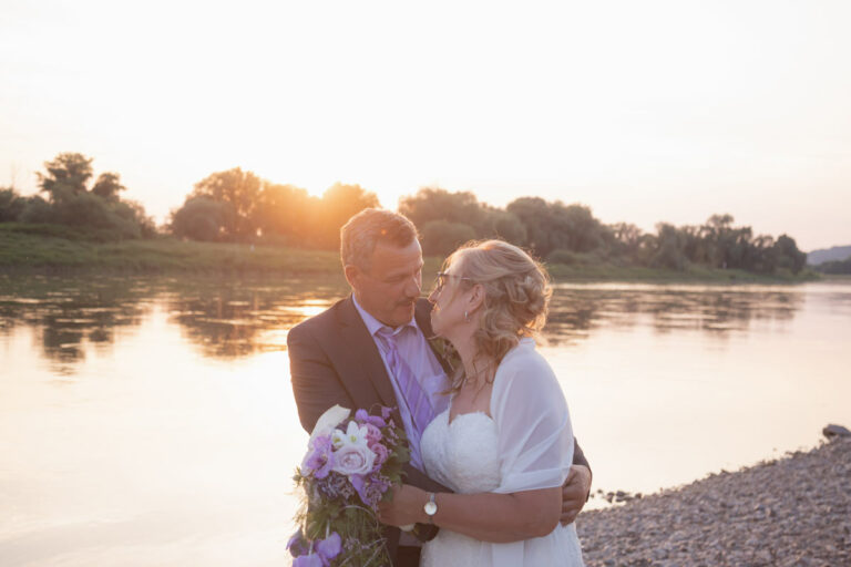 verliebtes Hochzeitspaar wird von einem Fotografen bei einem Sonnenuntergang fotografiert