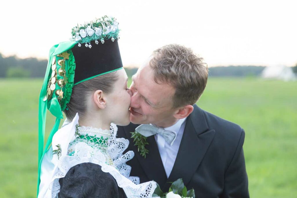 Hochzeitsfotograf in Bautzen und Umgebung - zu sehen ist ein serbischer Brautpaar auf einer Wiese und sie küssen sich