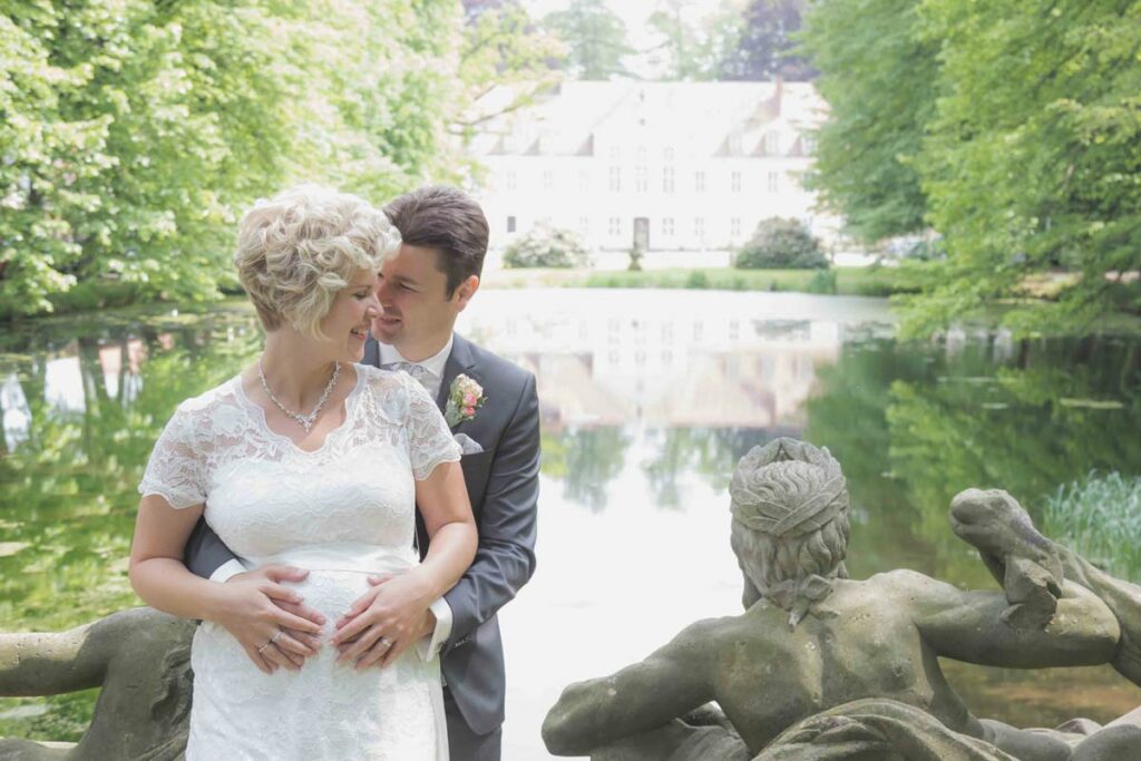 Hochzeitsfotograf Hoyerswerda - Brautpaar steht eng beieinander an einem Schloss und freuen sich