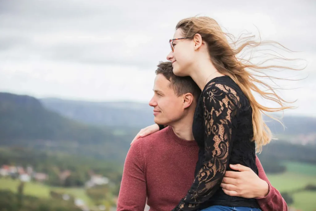 Verlobungsfotos - paar - in Dresden und der Sächsischen Schweiz - Paar sitzt beieinander und schaut auf die Berge