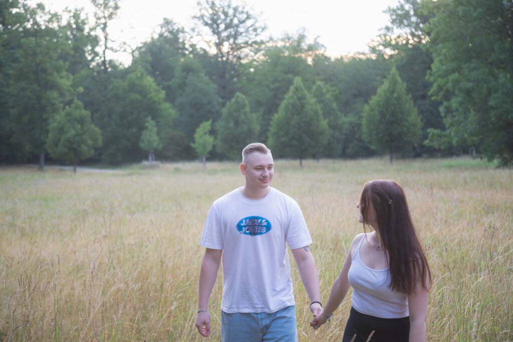 Sommer Fotos in Dresden während eines Fotoshootings im Großen Garten. Das verliebte Paar läuft auf einer Wiese.