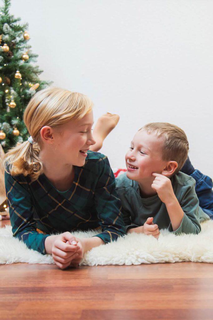 fotoshooting zu weihnachten zu hause mit der familie und einem geschmückten weihnachtsbaum