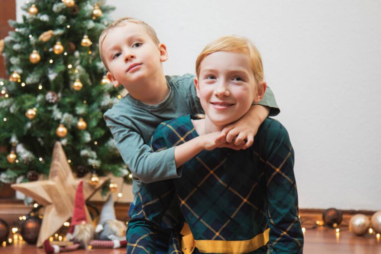 Fotoshooting in Dresden zu Weihnachten - zwei Kinder umarmen sich und freuen sich auf die Festtage