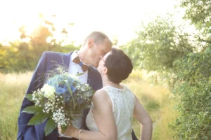 Brautpaarshooting zum Sonnenuntergang auf einer Wiese in Lichtenau. Brautpaar küssen sich und genießen den Moment - Hochzeitsfotograf Coswig