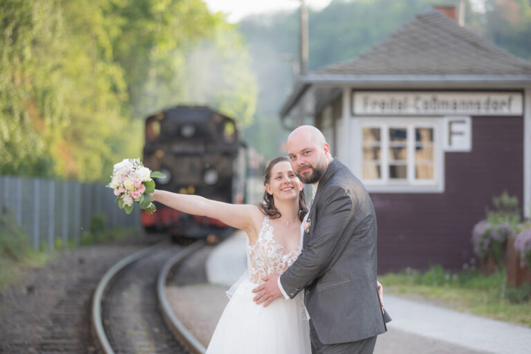 Braut und Bräutigam stehen auf dem Schienen der Weißeritztalbahn in Freital.