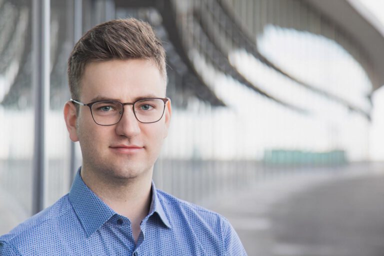 Ein Mann steht an einer Fensterfront in Dresden - ein Bewerbungsfoto was modern und schlicht wirkt