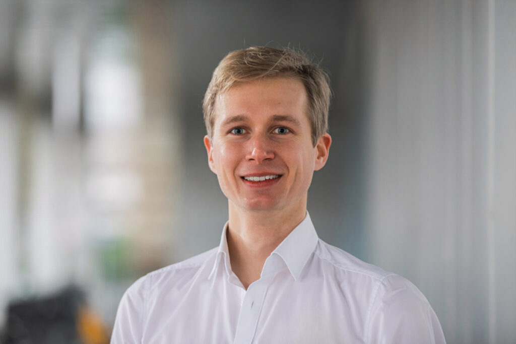 Bewerbungsfoto eines jungen Mannes in Dresden mit einem natürlichen Hintergrund außerhalb des Studios