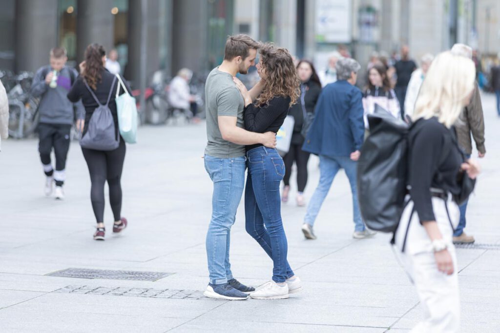 ein Paar steht eng beieinander. Fotoshooting in einer Fußgänger Passage in Dresden. Das liebes Paar zeigt die Liebe und lässt sich von niemanden stören.