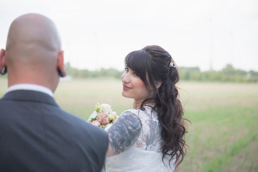 Brautpaarshooting in Meißen eines Paares. Die Braut schaut zu ihrem Mann und läuft vorneweg... Sie ist glücklich und schaut verliebt ihren Ehemann an - Hochzeitsfotograf Meißen