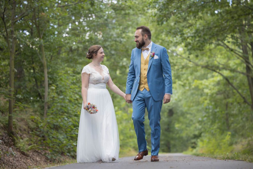 Brautpaar gehen einen Weg entlang und schauen sich dabei verliebt an - Brautpaarshooting Meißen - Hochzeit