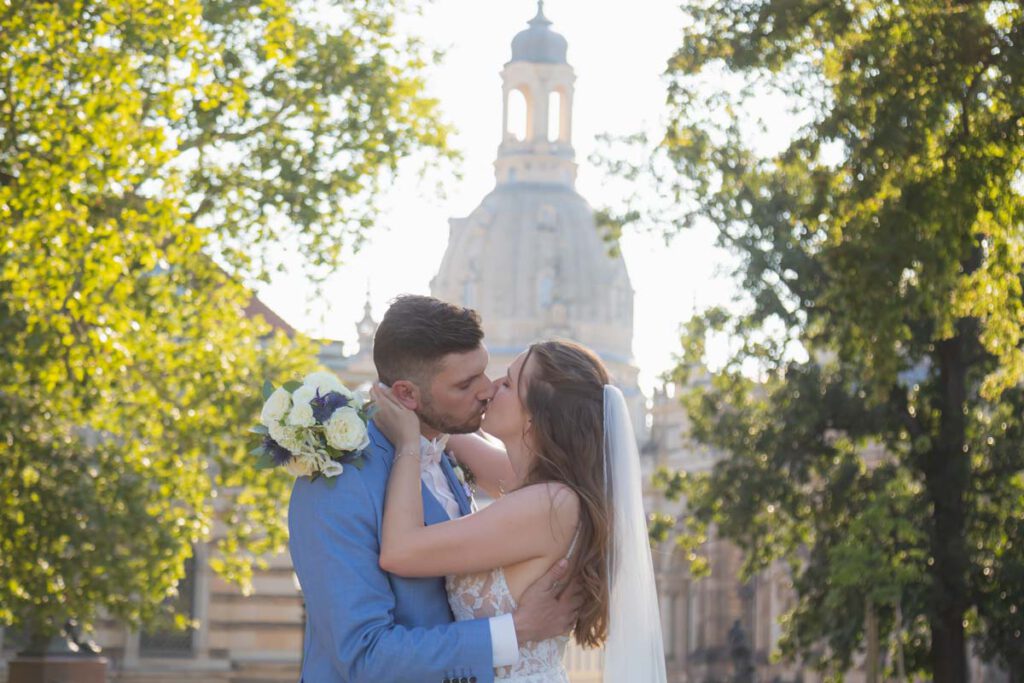 Brautpaar küsst sich. Im Hintergrund ist die Frauenkirche zu sehen. Brautpaarshooting der Hochzeit in Dresden