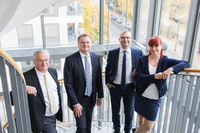 Mitarbeiter die zusammenstehen und von einem Fotografen fotografiert werden - Gruppenfotos Mitarbeiter Dresden