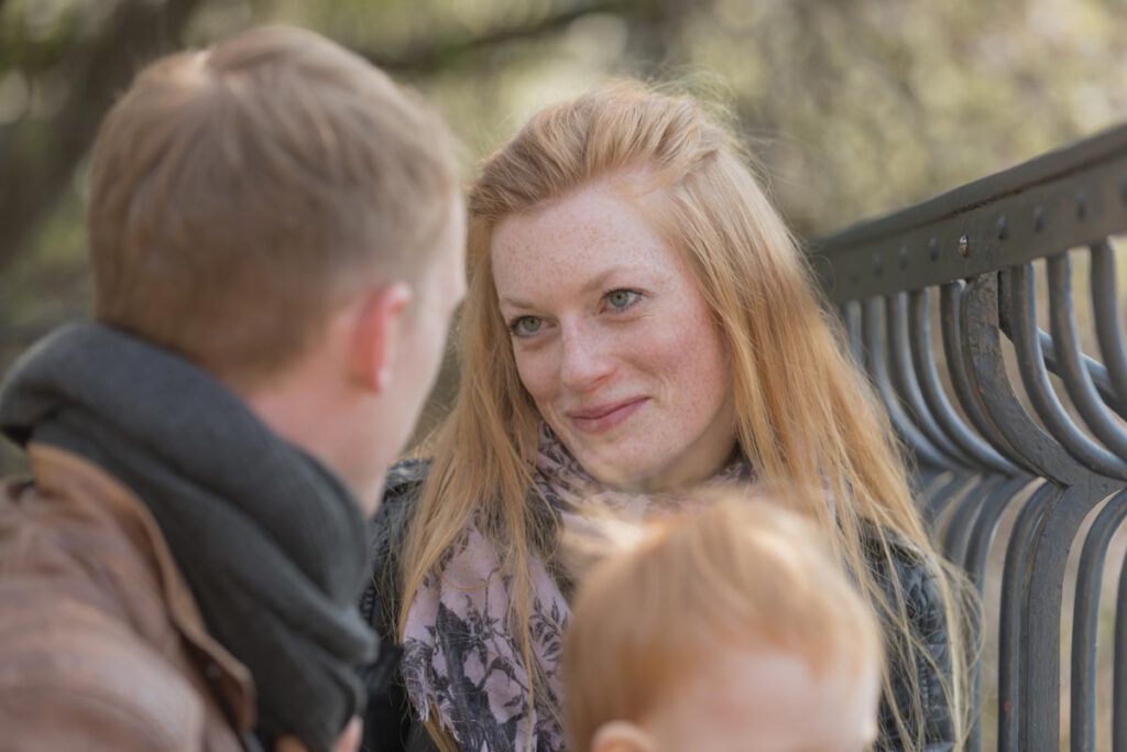 eine Frau schaut ihren Mann verliebt an und der Junge sitzt auf den Schoß vom Papa