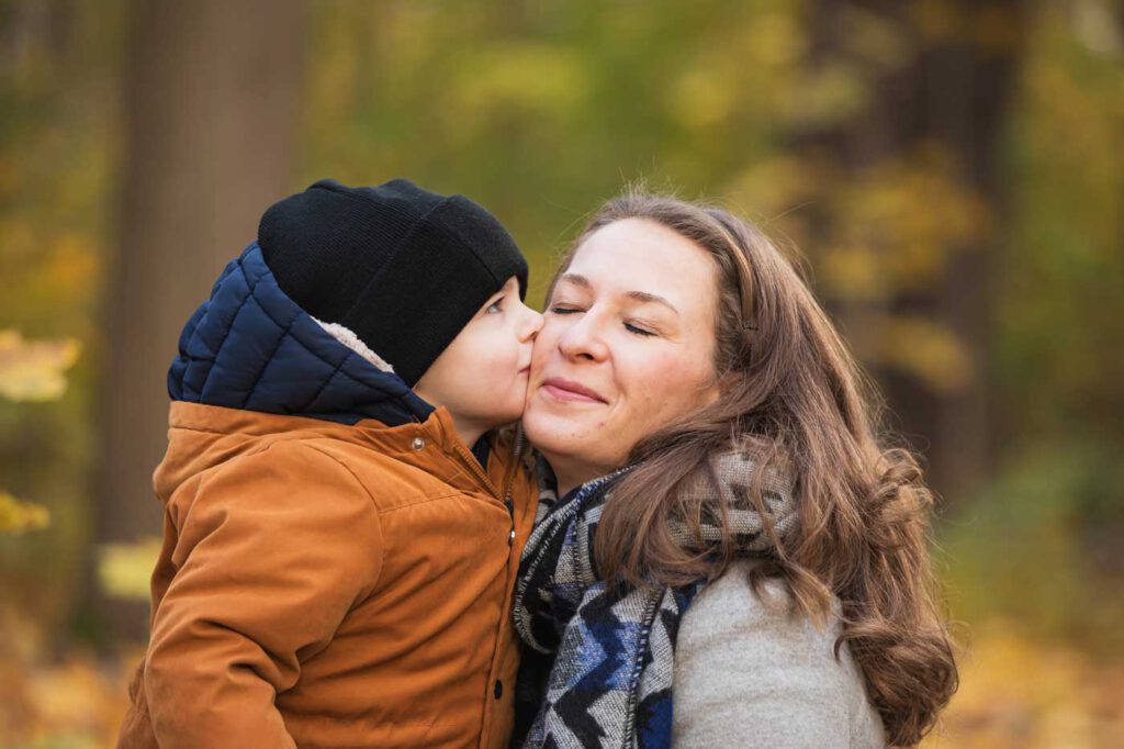Sohn küsst Mama auf die Wange - Herbst Fotoshooting